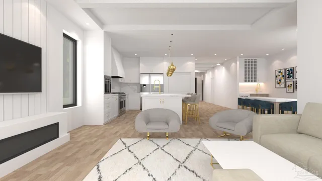 a living room with stainless steel appliances furniture a flat screen tv and a kitchen view