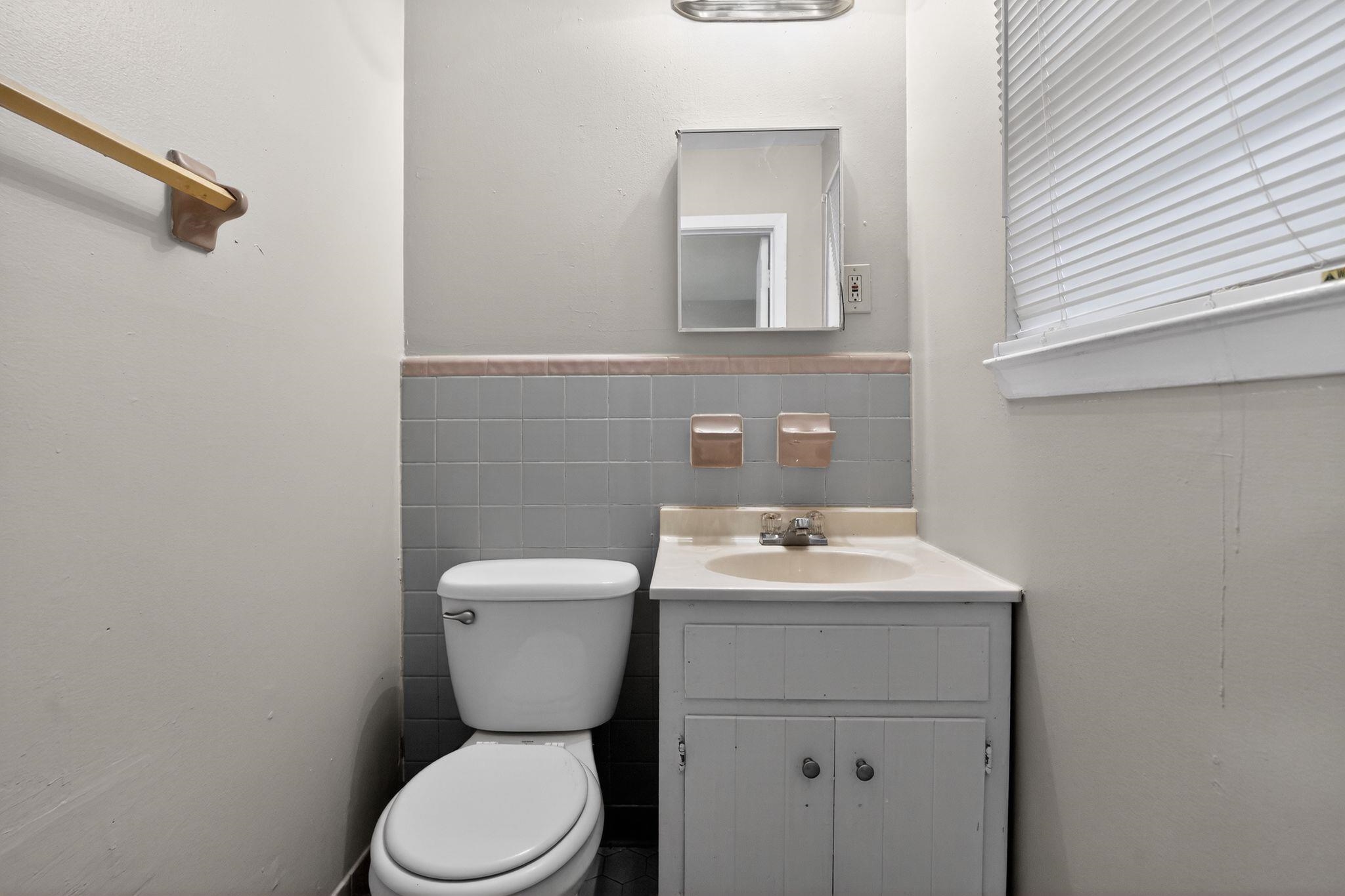 4566 Weaver Road Memphis, TN 38109 - Photo 22 of 32 a bathroom with a toilet sink and mirror