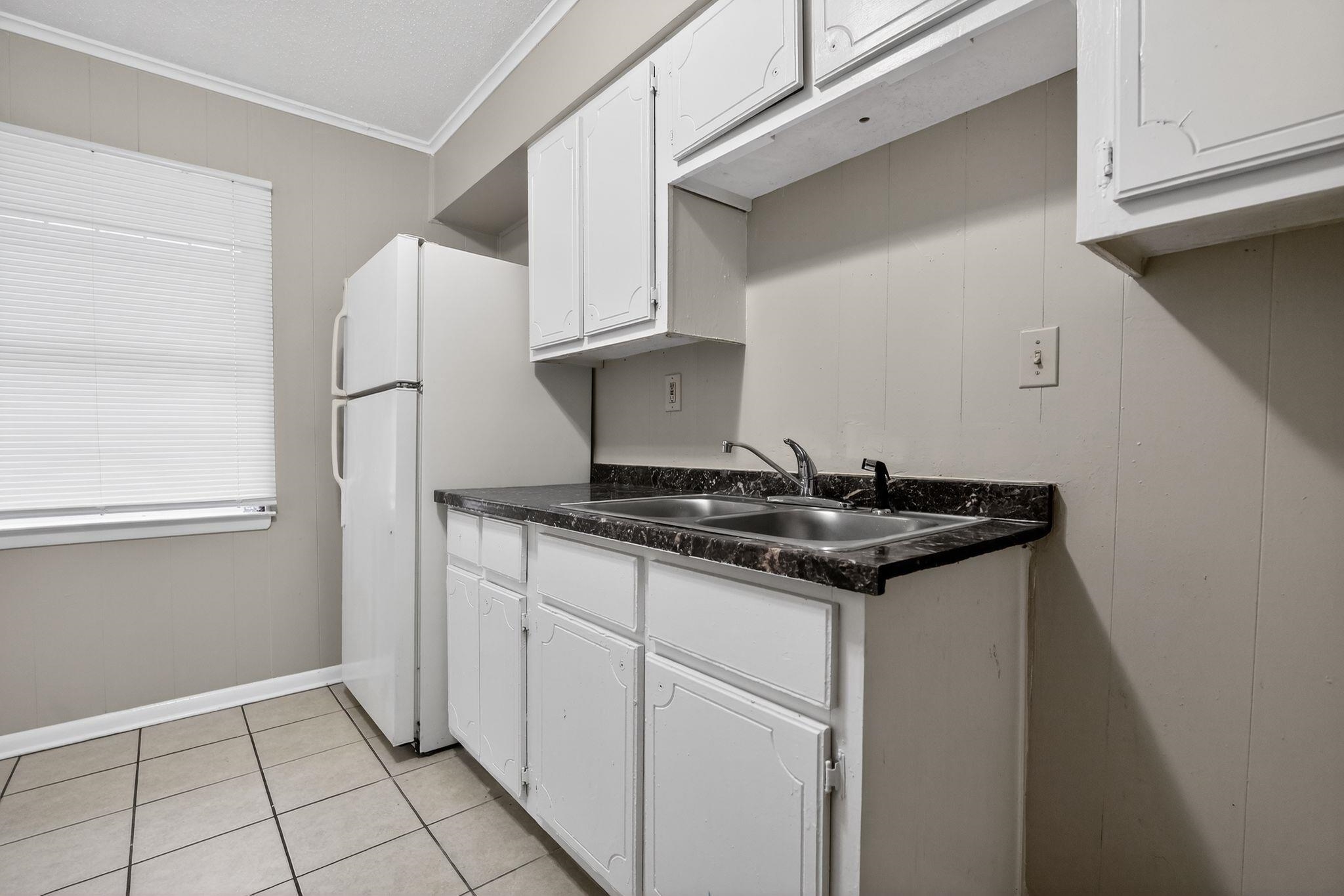 4566 Weaver Road Memphis, TN 38109 - Photo 10 of 32 a kitchen with granite countertop a sink and a stove