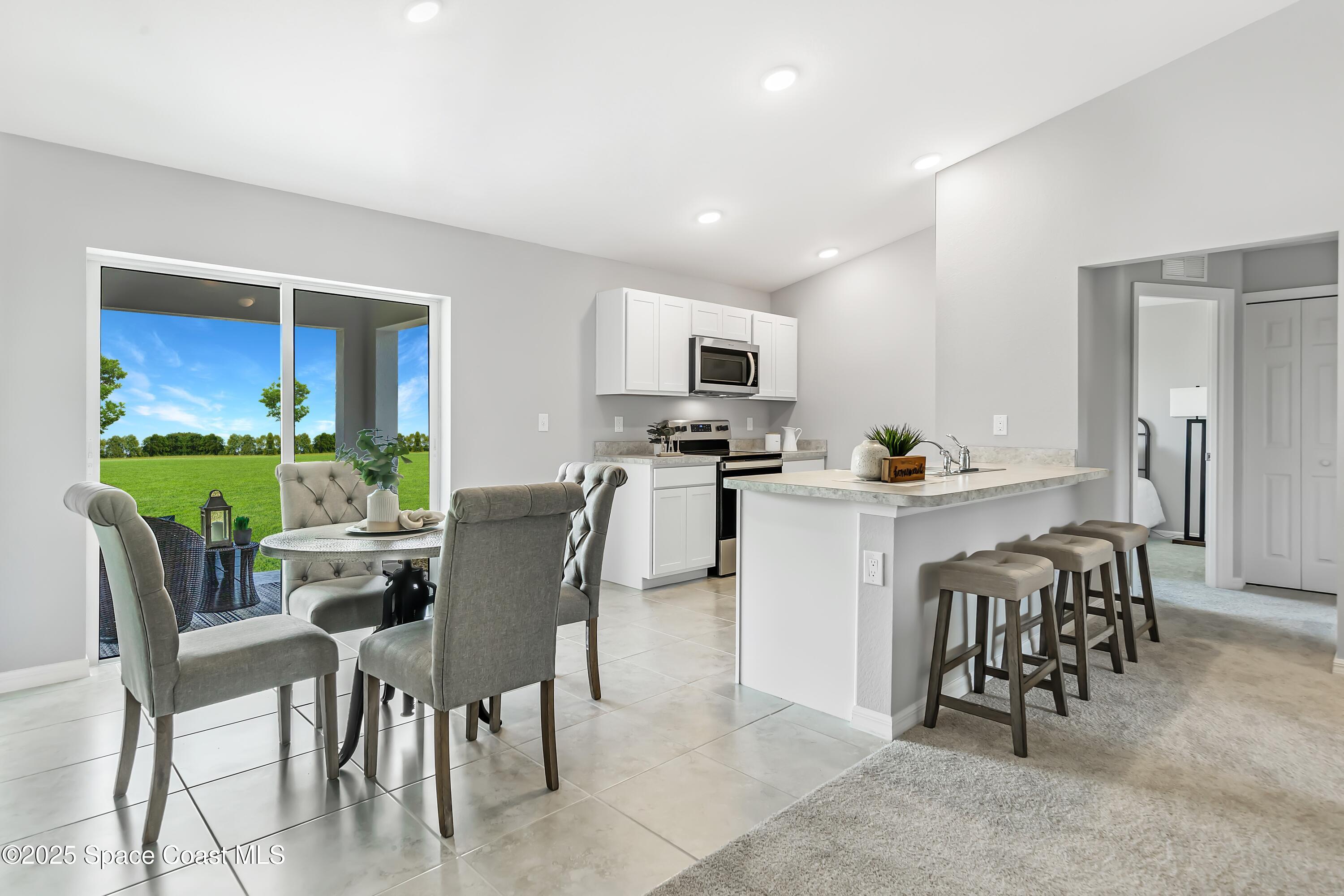 2981 Gabrysh Avenue Southeast Palm Bay, FL 32909 - Photo 5 of 12 a view of kitchen with dining table chairs and refrigerator