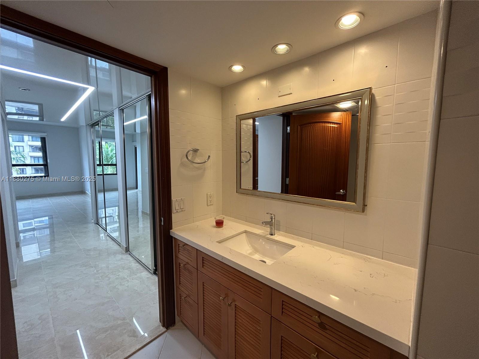 251 Crandon Boulevard, Unit 424 Key Biscayne, FL 33149 - Photo 18 of 22 a bathroom with a sink and a mirror