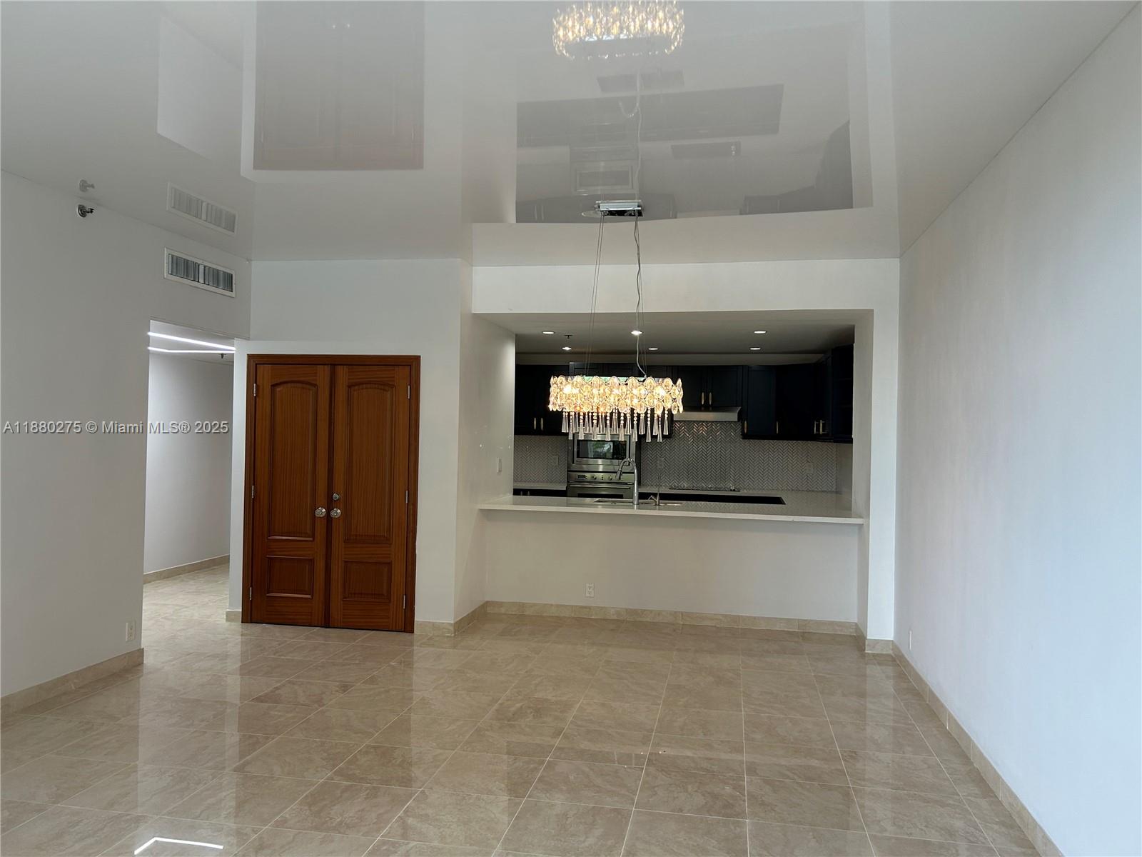 251 Crandon Boulevard, Unit 424 Key Biscayne, FL 33149 - Photo 6 of 22 a room with a chandelier and view of kitchen