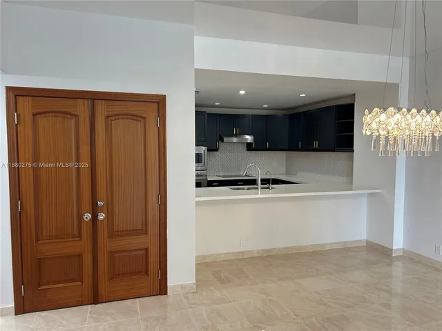 a kitchen with kitchen island granite countertop a refrigerator and a sink