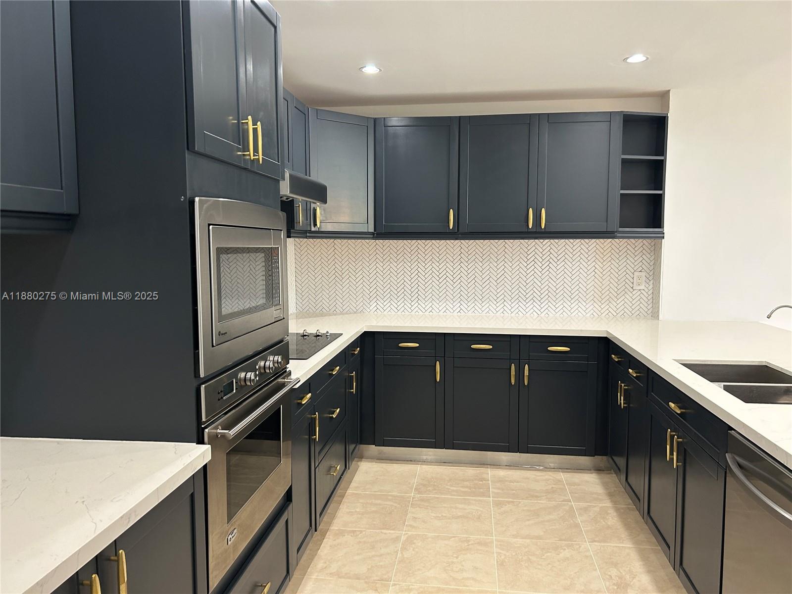 251 Crandon Boulevard, Unit 424 Key Biscayne, FL 33149 - Photo 9 of 22 a kitchen with kitchen island granite countertop a refrigerator and a sink