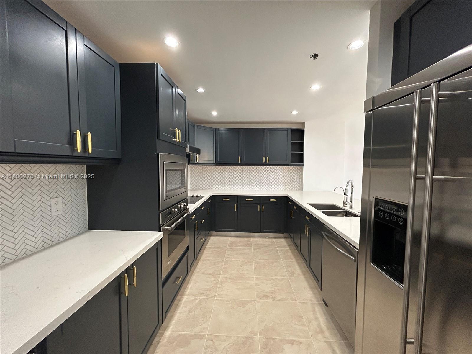 251 Crandon Boulevard, Unit 424 Key Biscayne, FL 33149 - Photo 10 of 22 a large kitchen with a large counter top stainless steel appliances and cabinets