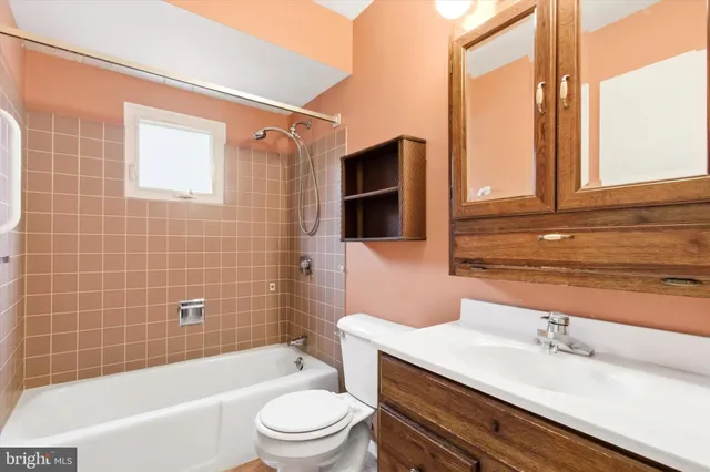 a bathroom with a sink a toilet a mirror and shower