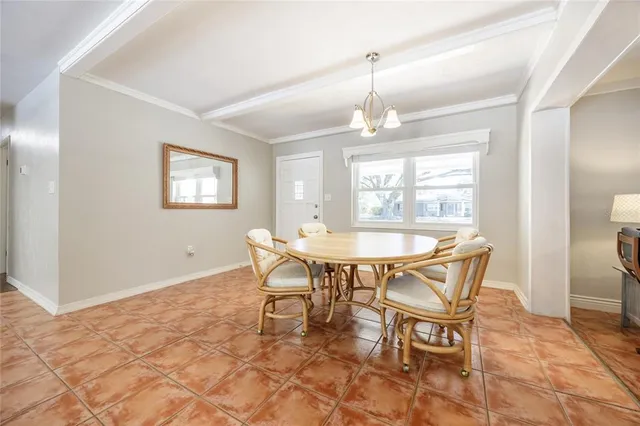 a dining room with furniture a chandelier and wooden floor