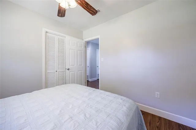 a bedroom with a large bed and a chandelier fan