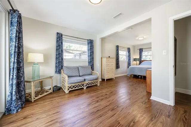 a living room with furniture and a wooden floor