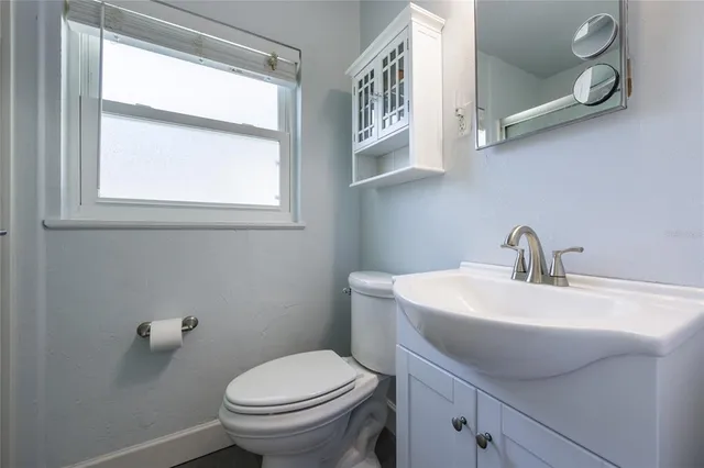a bathroom with a toilet sink and mirror