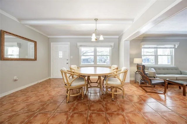 a dining room with furniture a chandelier and wooden floor
