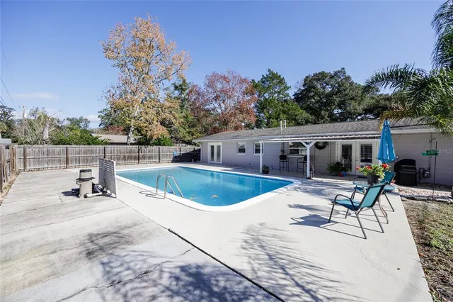 a view of house with swimming pool and sitting area