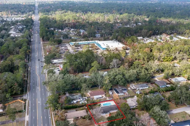 an aerial view of a house with a lake and a yard