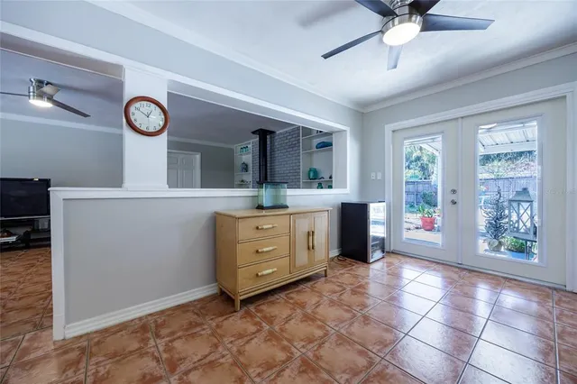 a room with a chandelier fan and windows