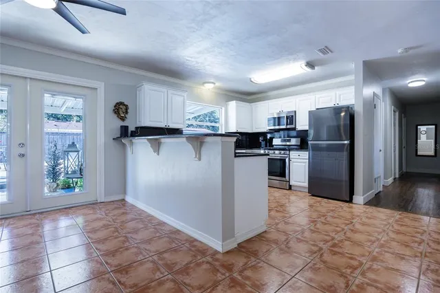 a kitchen with stainless steel appliances granite countertop a refrigerator and a stove top oven