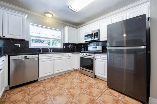 a kitchen with white cabinets stainless steel appliances and sink