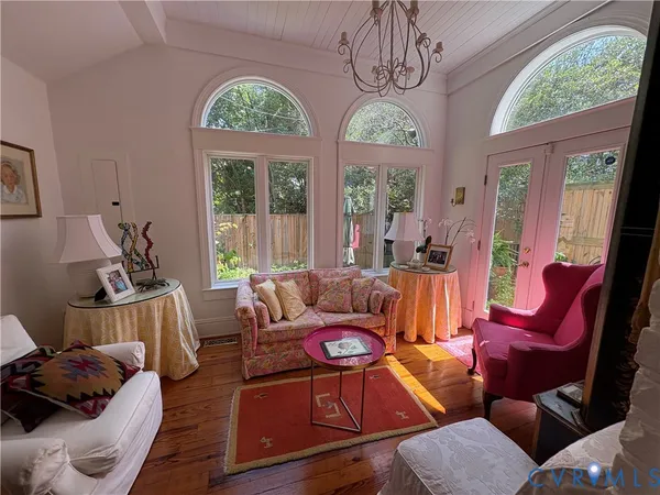a living room with furniture a chandelier and a large window