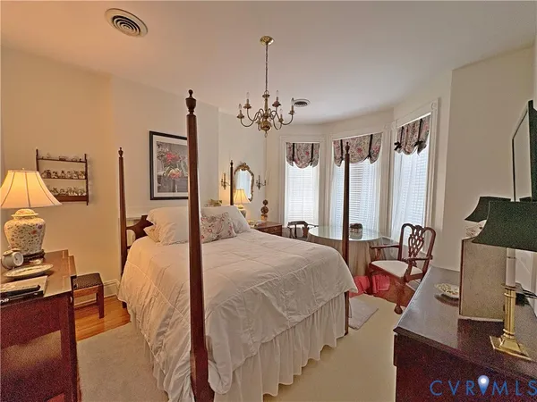 a bed room with a bed mirror and a desk