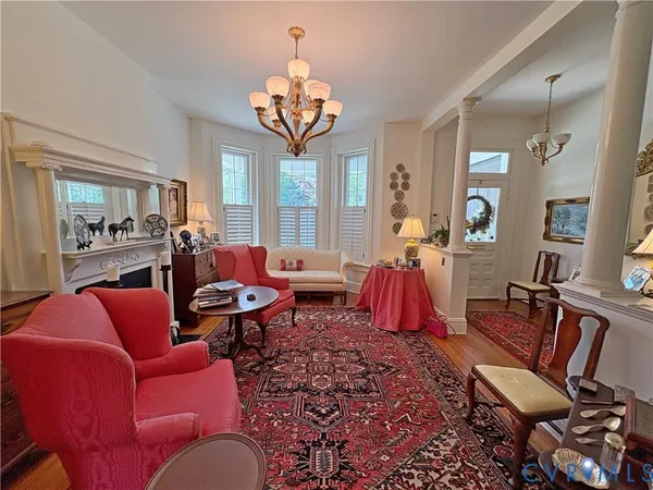 a living room with furniture a chandelier and a dining table