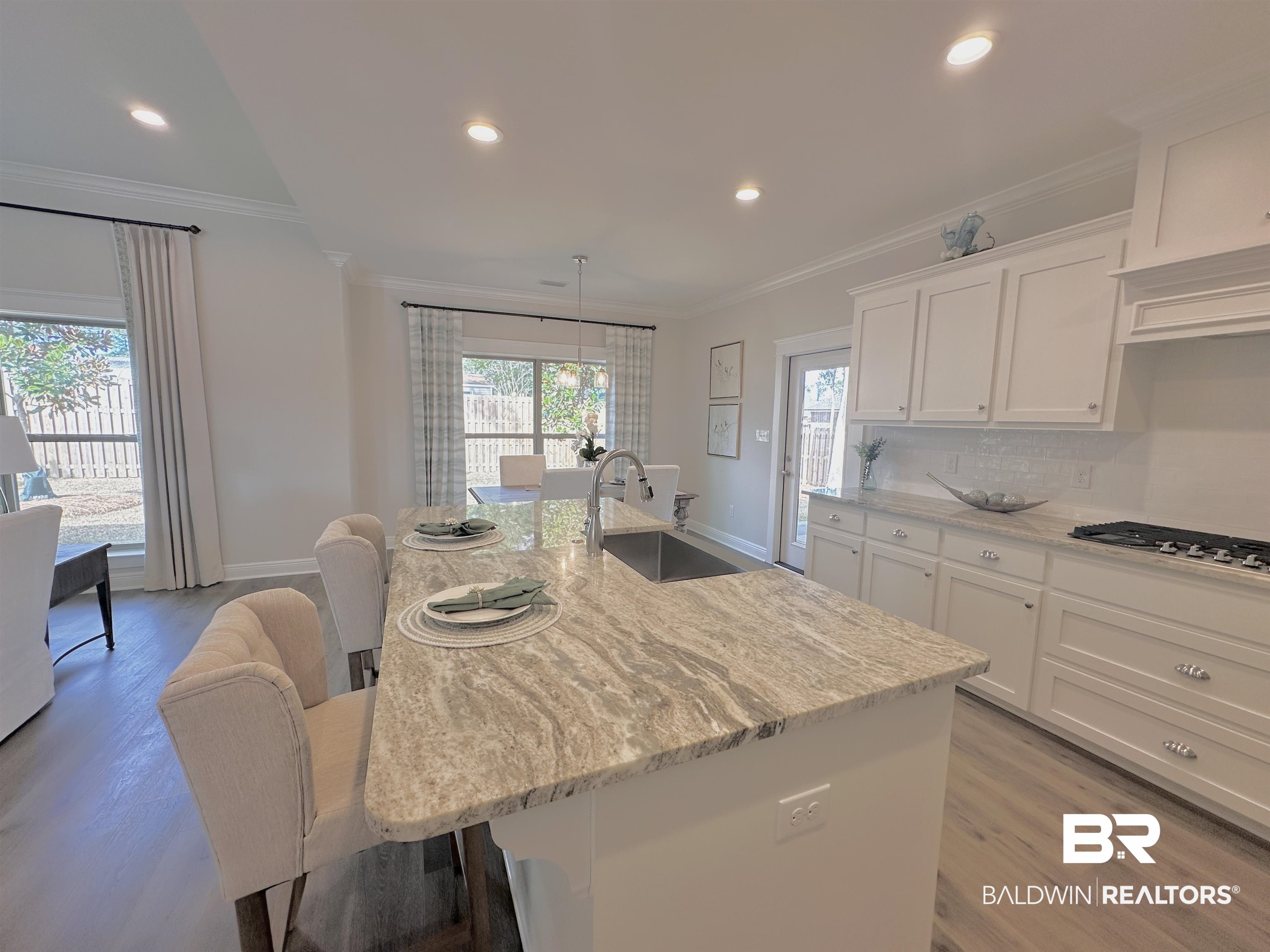 691 Kitfox Avenue Fairhope, AL 36532 - Photo 6 of 42 Kitchen with a kitchen island with sink, sink, a breakfast bar, and white cabinets