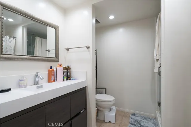 a bathroom with a sink a toilet a mirror and shower