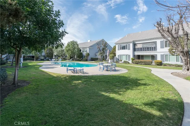 a front view of a building with garden and trees
