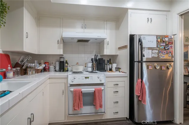 a kitchen with stainless steel appliances a refrigerator and cabinets