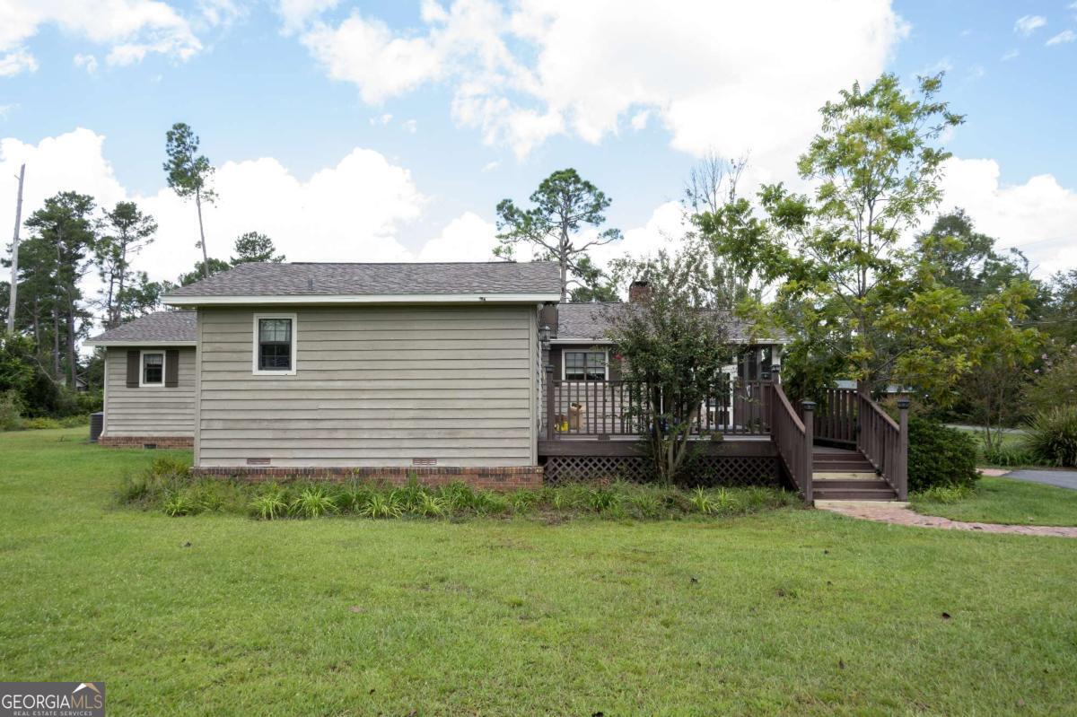 371 Burketts Ferry Road Hazlehurst, GA 31539 - Photo 14 of 53 a view of a backyard with plants and a large tree