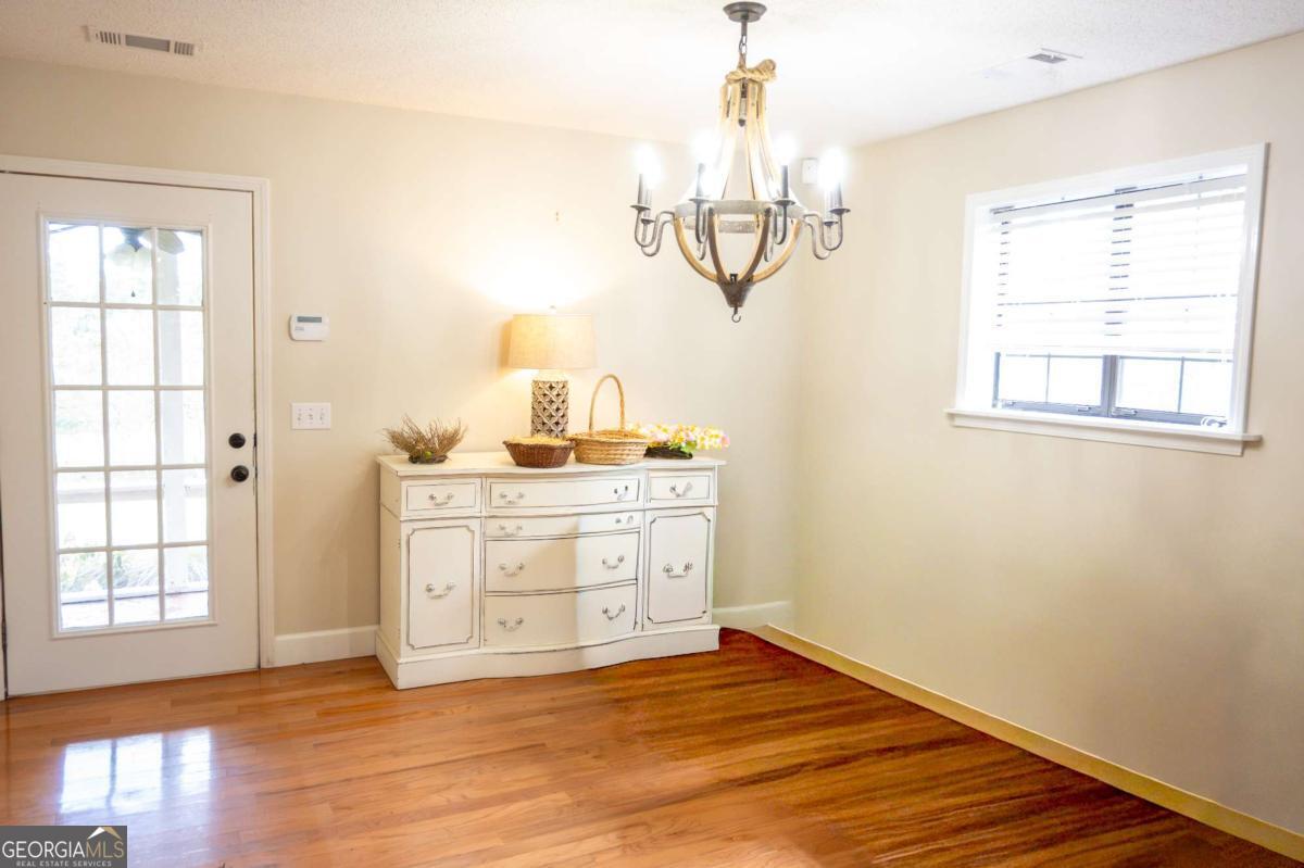 371 Burketts Ferry Road Hazlehurst, GA 31539 - Photo 17 of 53 a view of a room with wooden floors and chandelier