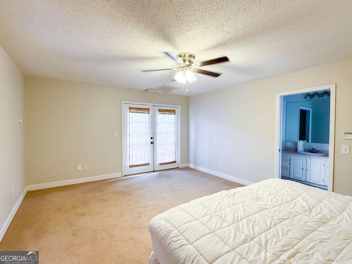 371 Burketts Ferry Road Hazlehurst, GA 31539 - Photo 28 of 53 a bedroom with a bed and a chandelier