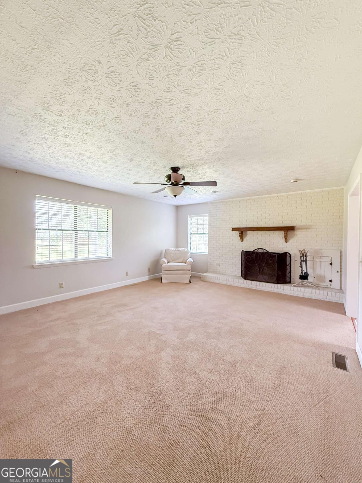 371 Burketts Ferry Road Hazlehurst, GA 31539 - Photo 34 of 53 an empty room with fireplace and windows
