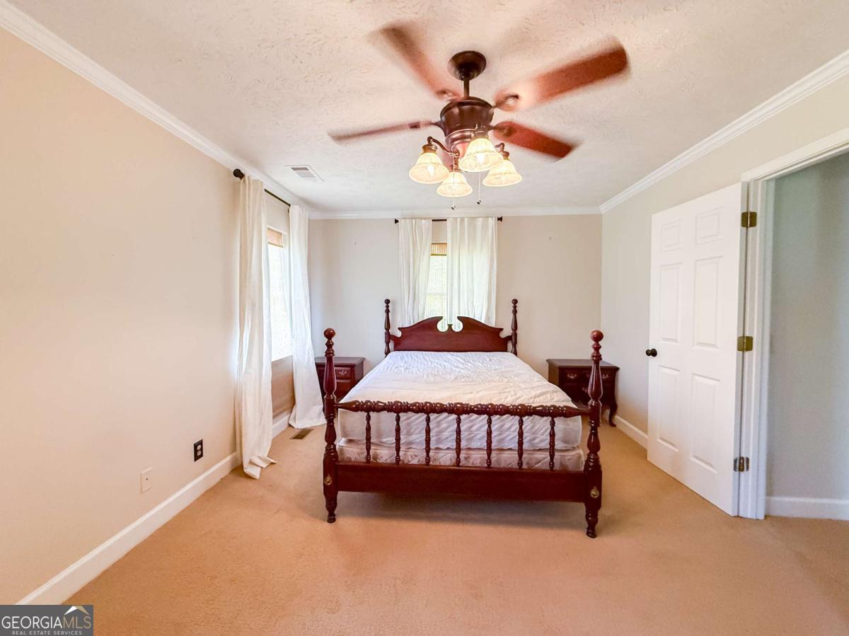 371 Burketts Ferry Road Hazlehurst, GA 31539 - Photo 39 of 53 a bedroom with a bed and a chandelier