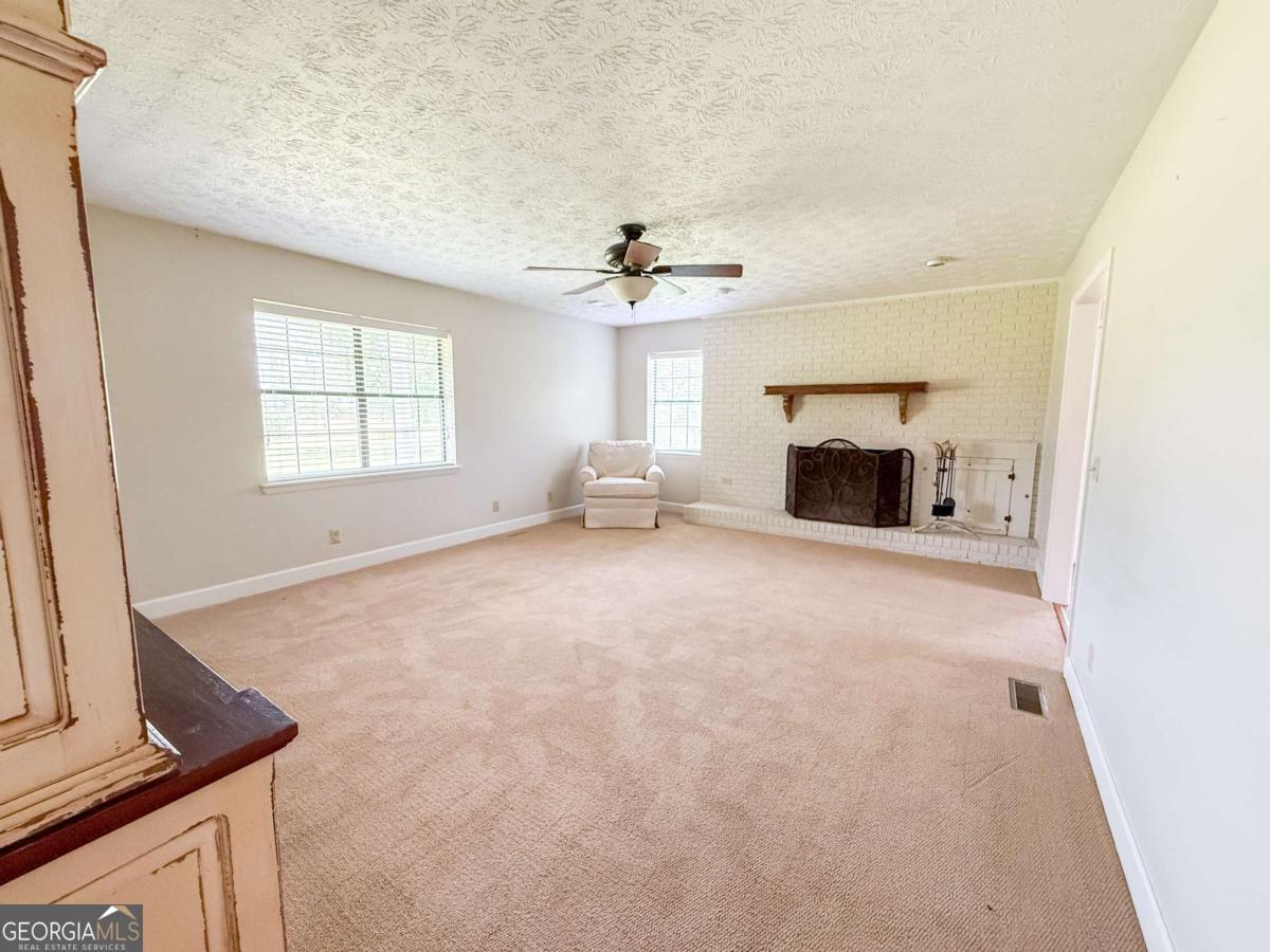 371 Burketts Ferry Road Hazlehurst, GA 31539 - Photo 46 of 53 a view of empty room with fireplace and windows