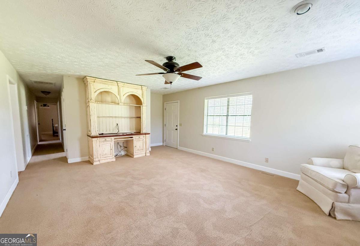 371 Burketts Ferry Road Hazlehurst, GA 31539 - Photo 47 of 53 an empty room with windows and ceiling fan