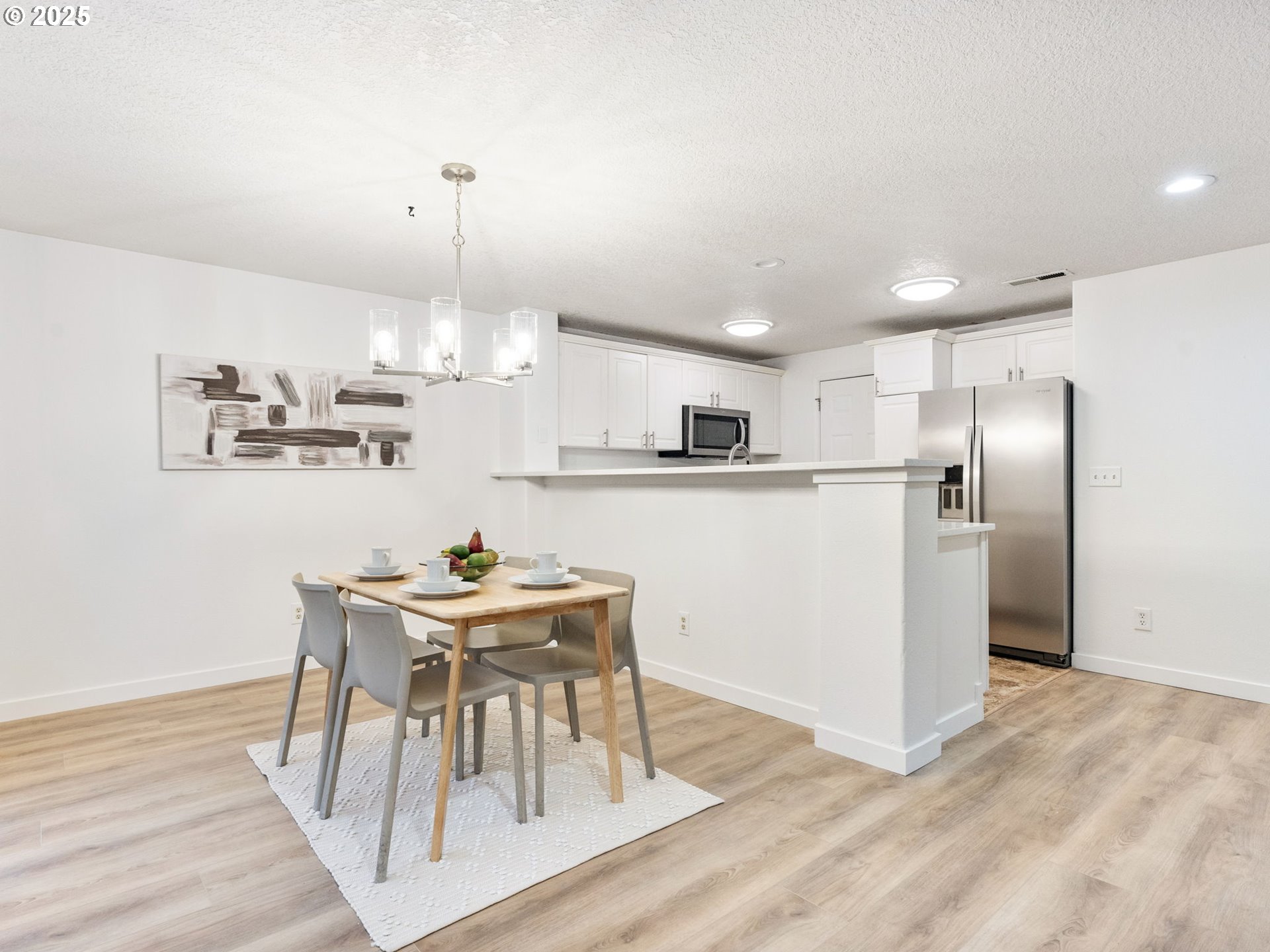 20744 Southwest Bingo Lane Beaverton, OR 97006 - Photo 10 of 26 a kitchen with kitchen island a refrigerator and a dining table