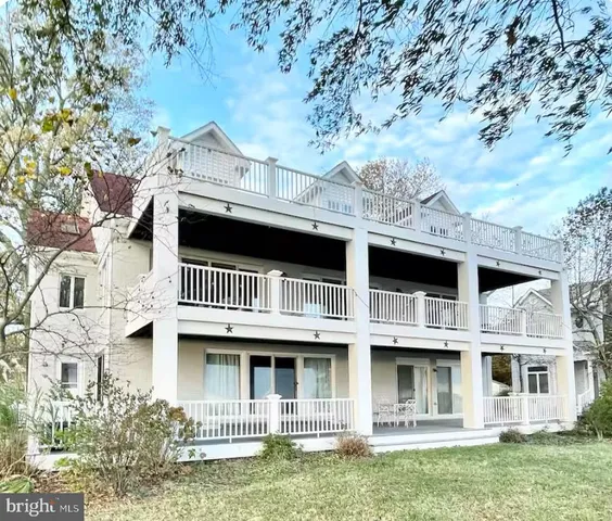 a view of a large building with a big yard and large trees