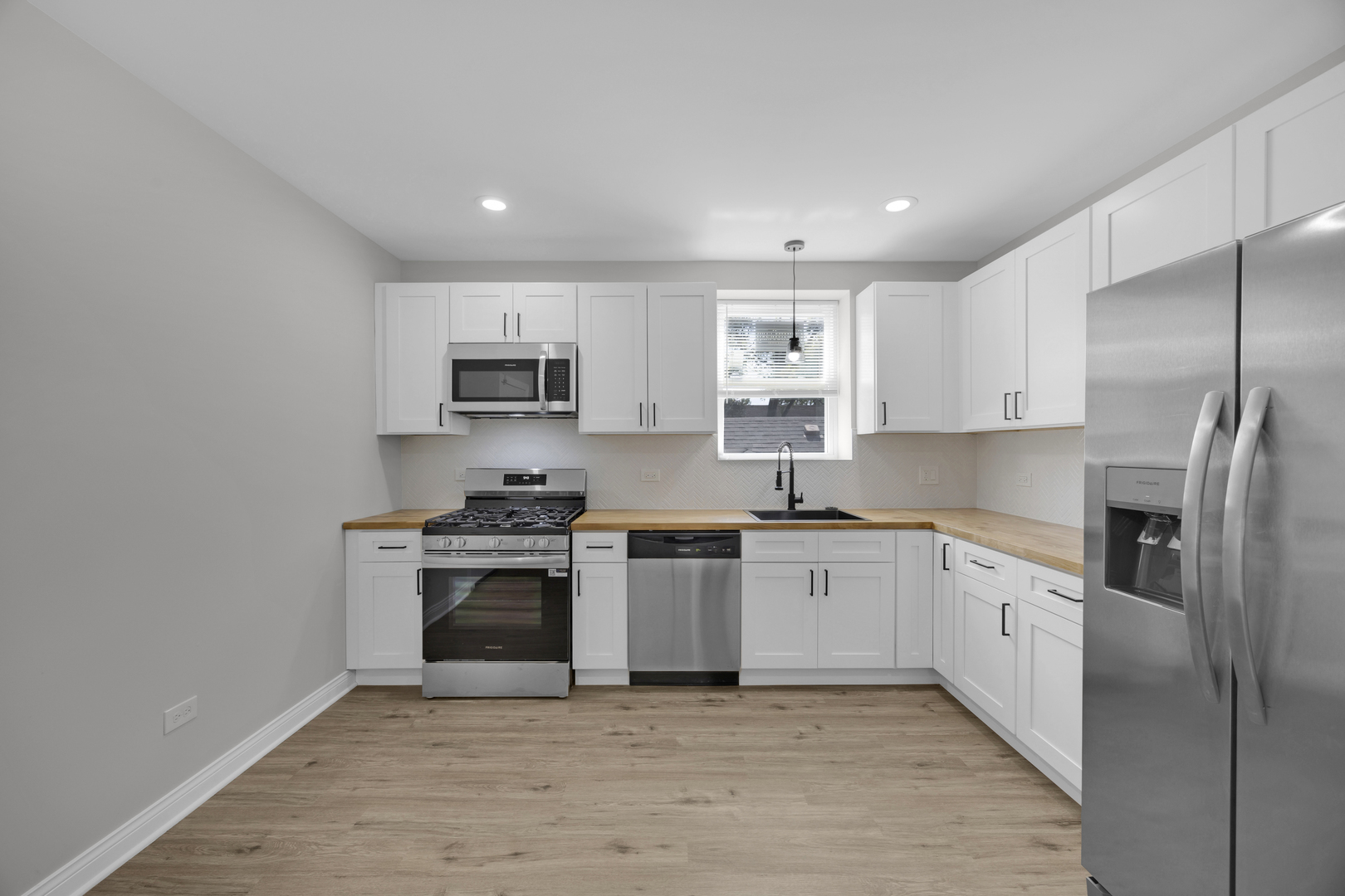 6807 South Paulina Street, Unit 1 Chicago, IL 60636 - Photo 3 of 5 a kitchen with stainless steel appliances granite countertop a stove top oven a sink and a refrigerator