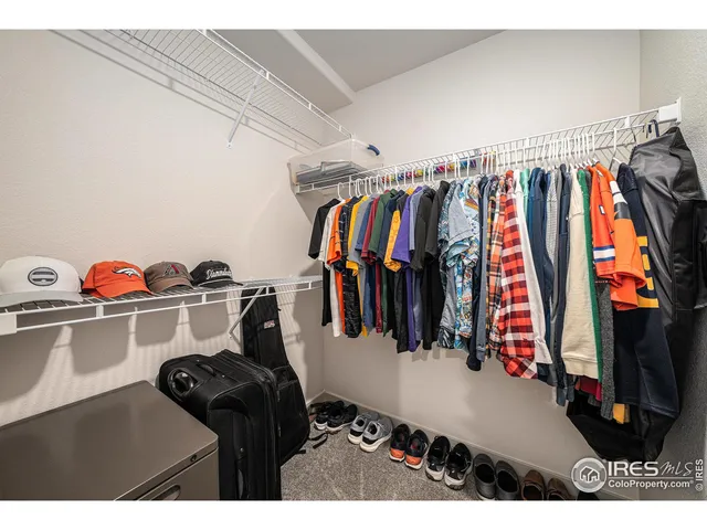 a view of walk in closet with clothes and shoes