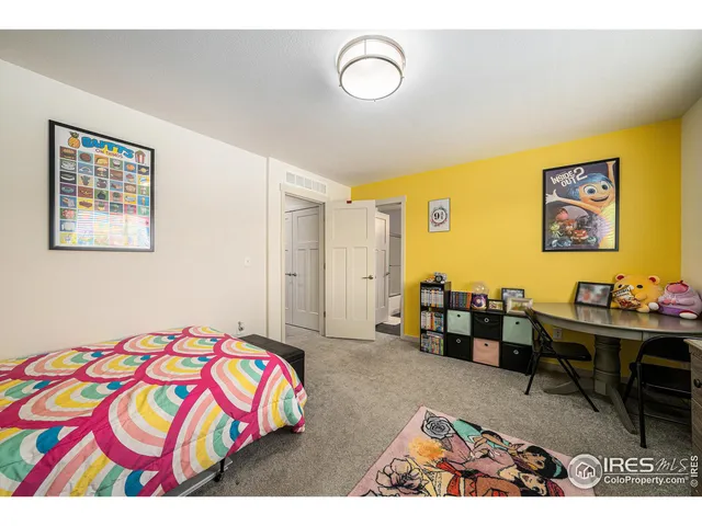 a bedroom with a bed and a lamp on dresser