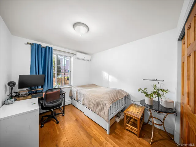 a bedroom with a bed table chair and a window