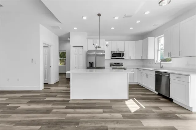 a view of kitchen with stainless steel appliances kitchen island sink stove and refrigerator