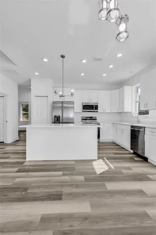 a view of kitchen with cabinets microwave and stove
