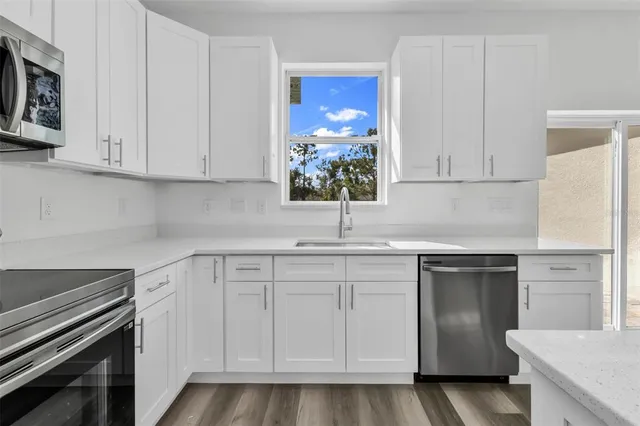 a kitchen with white cabinets and white appliances