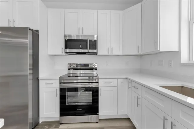 a kitchen with white cabinets and stainless steel appliances
