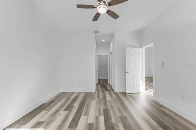 a view of a room with wooden floor and ceiling fan