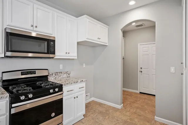 a kitchen with stainless steel appliances white cabinets and stove