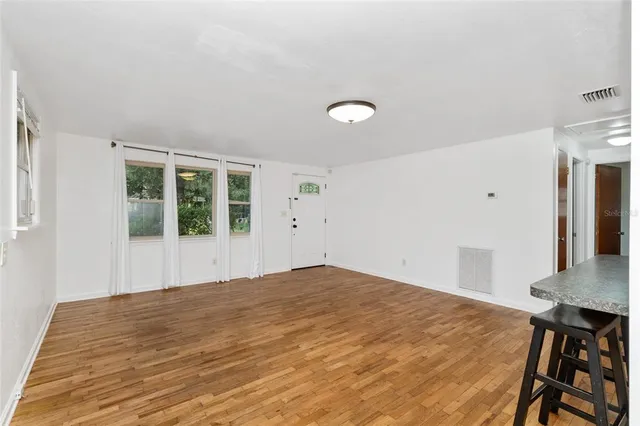 a view of a bedroom with wooden floor and windows
