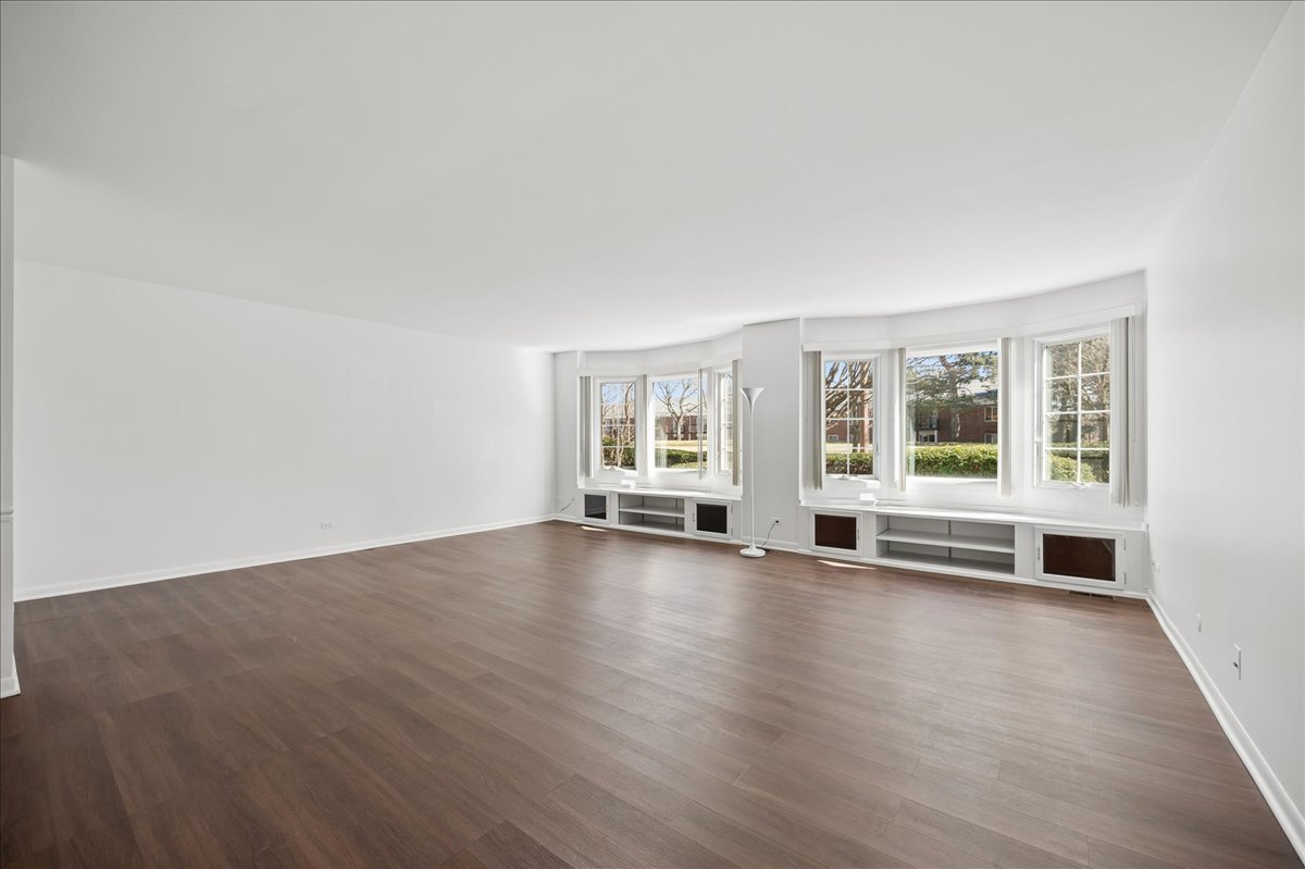 715 Ridge Road, Unit 1BN Wilmette, IL 60091 - Photo 6 of 15 an empty room with wooden floor and windows