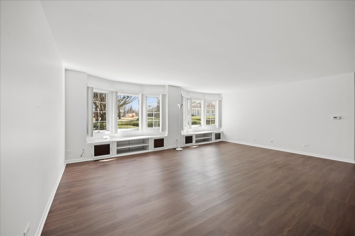 715 Ridge Road, Unit 1BN Wilmette, IL 60091 - Photo 8 of 15 an empty room with wooden floor and windows