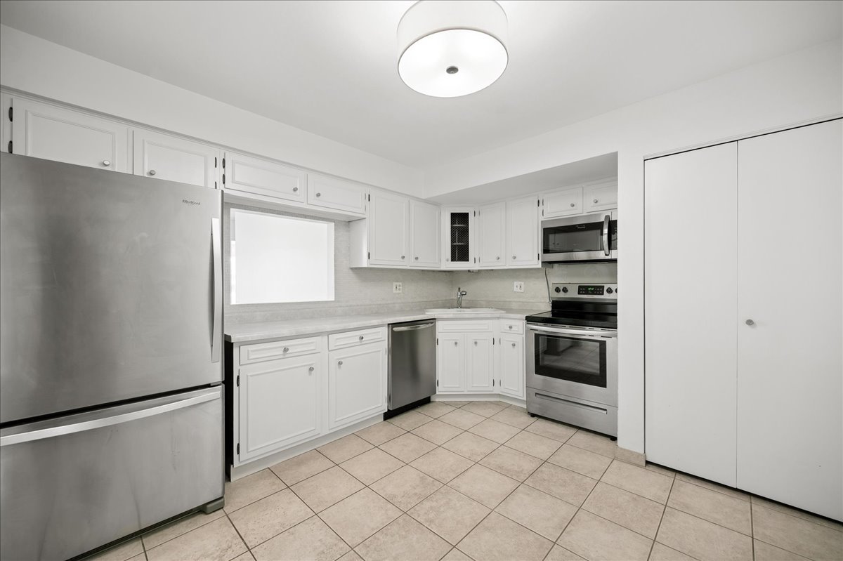 715 Ridge Road, Unit 1BN Wilmette, IL 60091 - Photo 10 of 15 a kitchen with white cabinets and white appliances